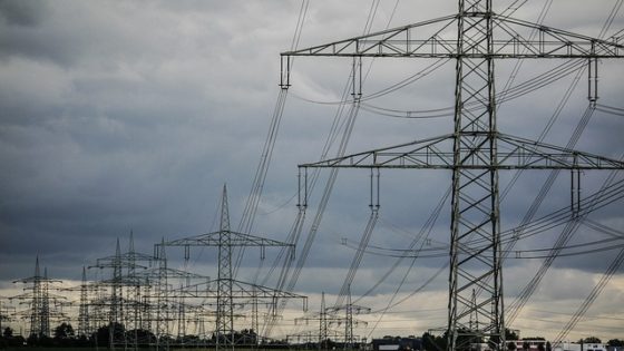 string of power lines in front of a cloudy, grey sky