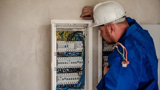 Electrical Technician looking at a fuse box