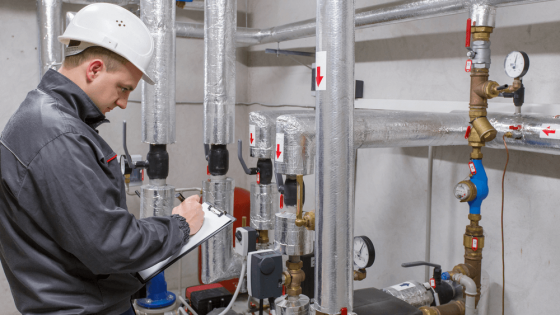 Technician inspecting heating system in boiler room